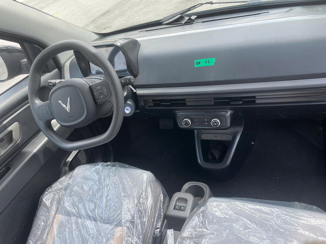 Không gian nội thất tông sáng với bảng điều khiển, màn hình và ghế nỉ.